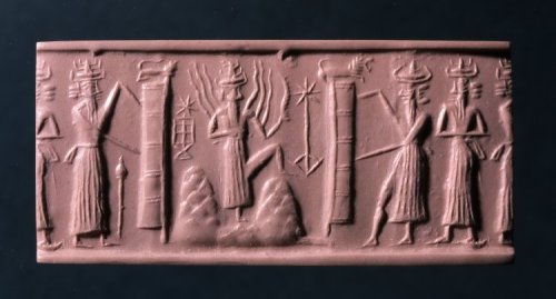 Illustration: Shamash the Sun-god rising on the horizon, flames of fire ascending from his shoulder. The two portals of the dawn, each surmounted by a lion, are being drawn open by attendant gods. From a Babylonian seal cylinder in the British Museum. [No. 89,110.]