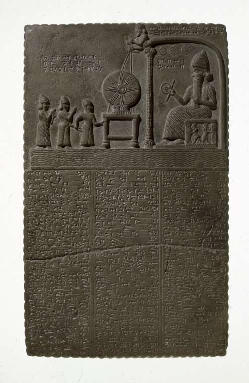 Illustration: Tablet sculptured with a scene representing the worship of the Sun-god in the Temple of Sippar.  The Sun-god is seated on a throne within a pavilion holding in one hand a disk and bar which may symbolize eternity.  Above his head are the three symbols of the Moon, the Sun, and the planet Venus.  On a stand in front of the pavilion rests the disk of the Sun, which is held in position by ropes grasped in the hands of two divine beings who are supported by the roof of the pavilion.  The pavilion of the Sun-god stands on the Celestial Ocean, and the four small disks indicate either the four cardinal points or the tops of the pillars of the heavens.  The three figures in front of the disk represent the high priest of Shamash, the king (Nabu-aplu-iddina, about 870 B.C.) and an attendant goddess. [No. 91,000.]