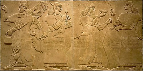 A King, Ashurnasirpal, interacts with an attendant at far right. An apkallu is depicted at far left, denoted by his wings and his characteristic pose, with raised right hand and left hand holding a bucket. Apkallu in this pose typically have a cone in their right hands, which they use to ritually sprinkle water.