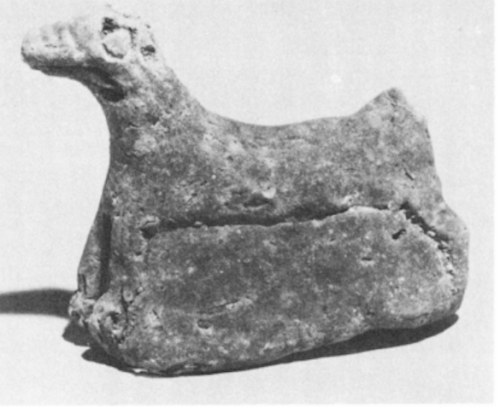 ND 8194 (MMA 59.107.27). Sun-dried clay figurine of a mušhuššu, discovered in the same foundation box as the figure of Plate XIa. Previously published: D. Oates, Iraq 21 (1959), Mallowan, N&R II. Double-catalogued by Rittig. Plate XIVd.